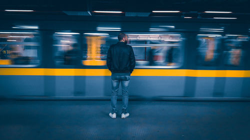 Blurred motion of woman standing at subway station