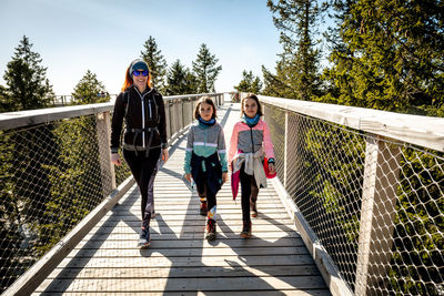 People on footbridge against trees