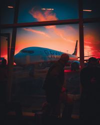 View of airplane at airport during sunset