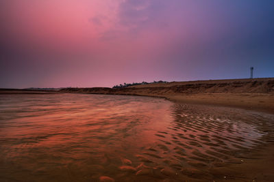 Scenic view of beach against sky during sunset