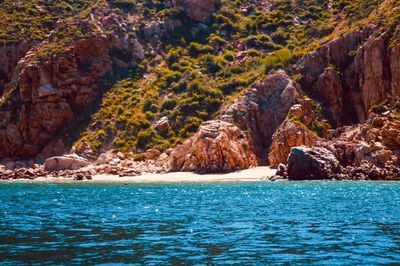 Rock formations by sea against sky 