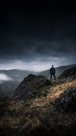 Man standing on mountain against sky