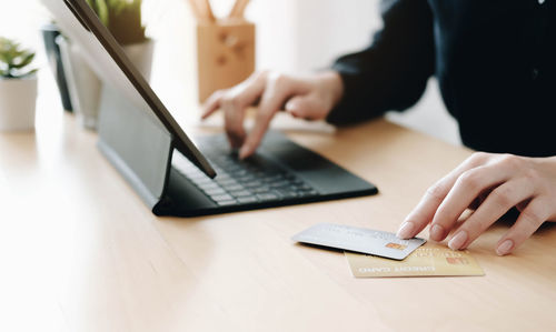 Midsection of woman using laptop on table