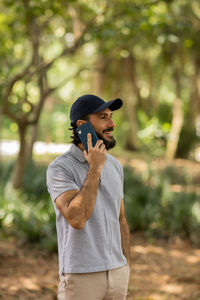 Young man at park on a beautiful sunny day with mobile phone.  working  leisure. green and nature 