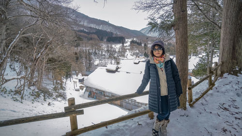 Portrait of woman standing on snow covered mountain