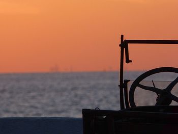 Close-up of vehicle at beach against clear sky during sunset