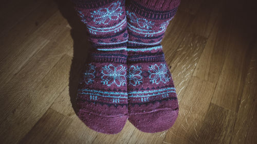 Low section of woman standing on hardwood floor