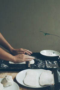 Cropped hand of person preparing food on table