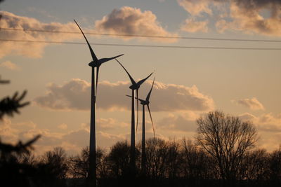 Silhouette of wind turbine against sky during sunset