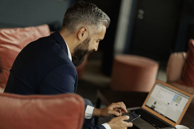 Businessman using cell phone in cafe