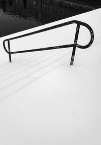 High angle view of snow covered land by lake