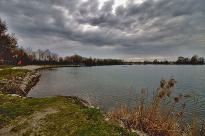 Scenic view of lake against cloudy sky