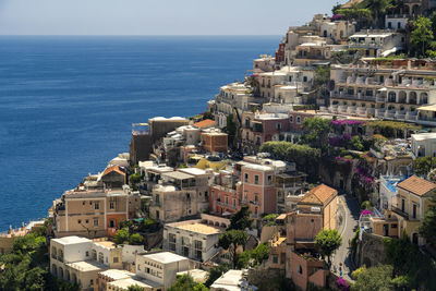 High angle view of townscape by sea against sky