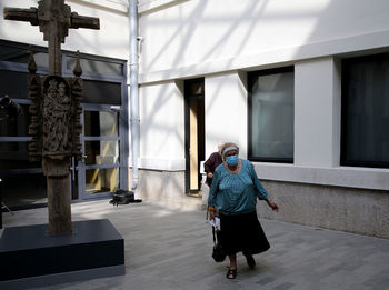 Rear view of people walking on building