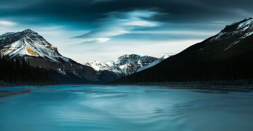 Scenic view of lake and snowcapped mountains against sky