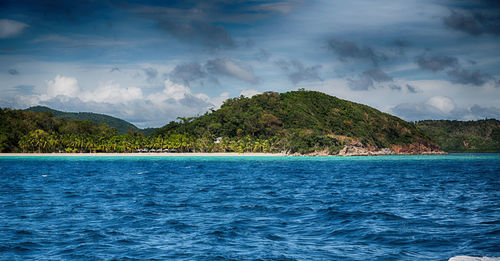 Scenic view of sea and mountains against sky