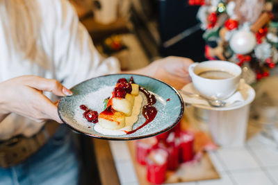 Midsection of woman having breakfast on table