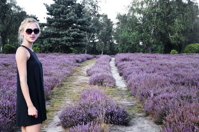 Young woman standing by lavender field