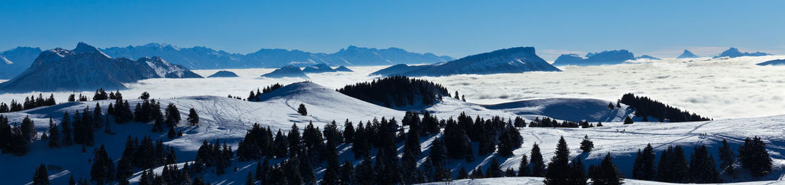 Panoramic view of snowcapped mountains against blue sky