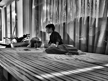 Boy sitting on bed at home