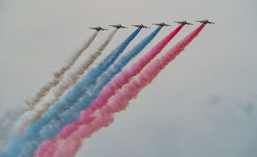 Low angle view of airshow against sky