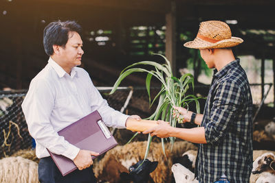 Financial advisor shaking hand with farmer at farm