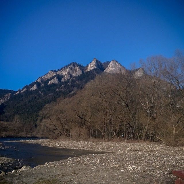 clear sky, mountain, blue, copy space, tranquil scene, tranquility, scenics, beauty in nature, nature, landscape, non-urban scene, rock - object, mountain range, rock formation, idyllic, remote, day, outdoors, sunlight, tree