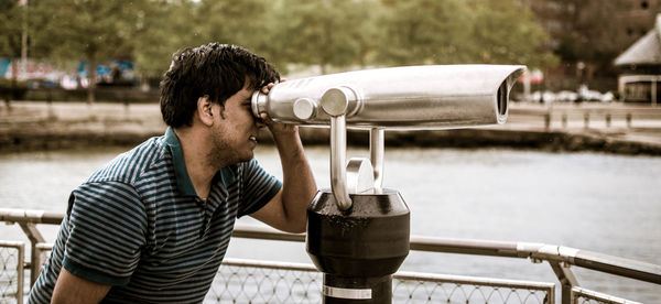 Man looking through binoculars at observation point