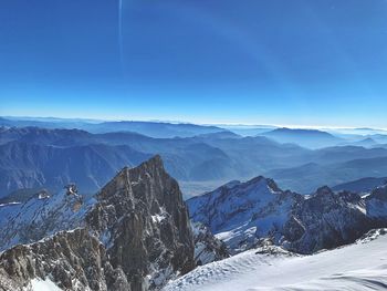 Scenic view of snowcapped mountains against blue sky