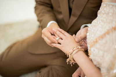 Midsection of couple holding hands