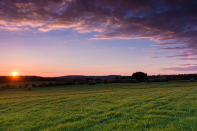 Scenic view of field against sky at sunset