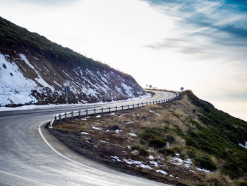 Road by mountain against sky