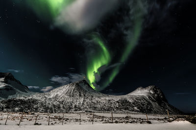 Scenic view of snowcapped mountain against sky at night