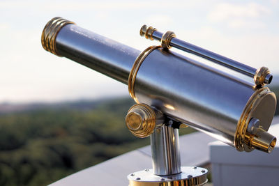 Close-up of coin-operated binoculars against sky