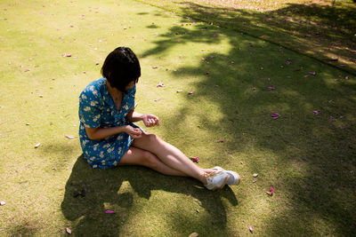 High angle view of girl sitting on field