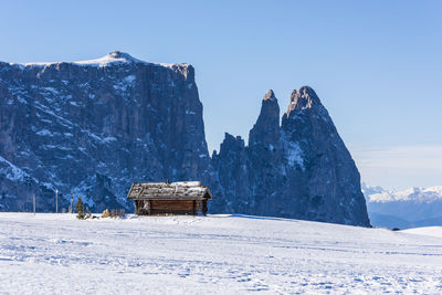 Built structure on snowcapped mountain against sky