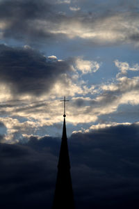 Low angle view of silhouette tower and building against sky