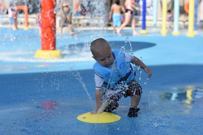 Full length of playful boy by sprinkler at hersheypark