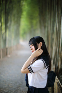 Side view of young woman in bamboo groove
