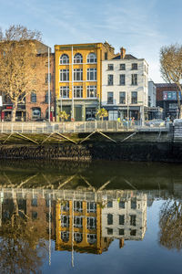 Reflection of buildings in canal against sky