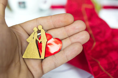 Close-up of person holding red leaf