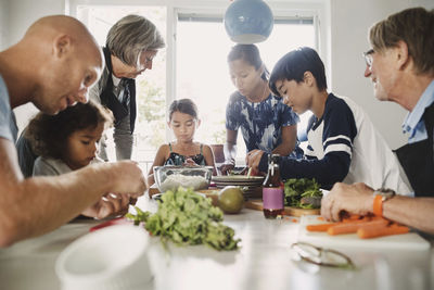 Multi-ethnic family preparing asian food at kitchen