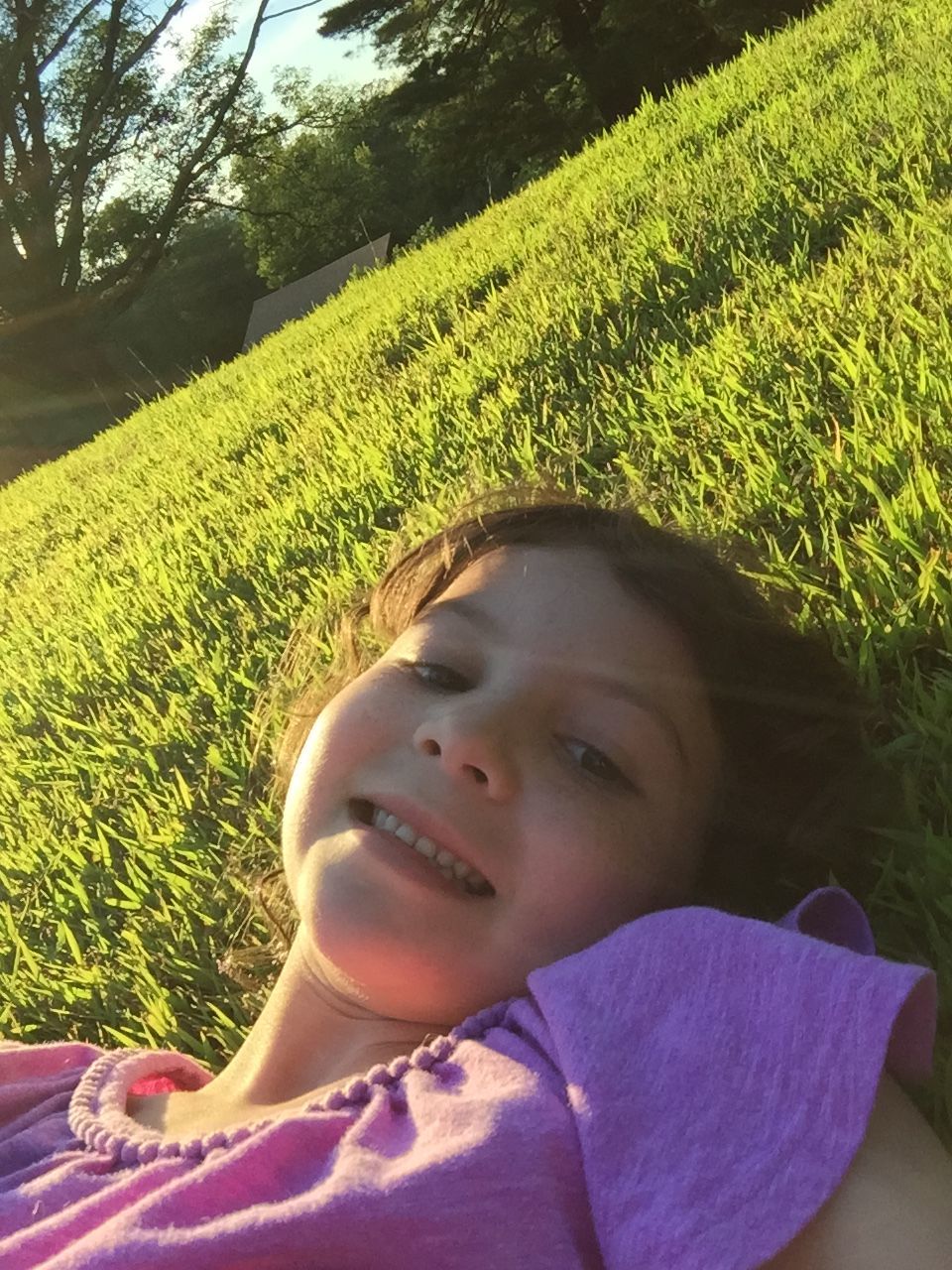 person, headshot, childhood, portrait, close-up, lifestyles, looking at camera, leisure activity, innocence, green color, cute, grass, growth, elementary age, field, sunlight, casual clothing