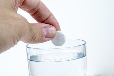 Midsection of person holding drink against white background