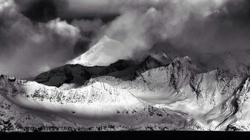 Scenic view of mountains against cloudy sky