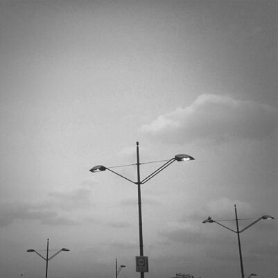 low angle view, street light, sky, lighting equipment, cloud - sky, pole, cloudy, silhouette, communication, dusk, outdoors, cloud, no people, high section, lamp post, electricity, nature, overcast, electric light, built structure