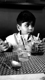Portrait of boy holding ice cream on table