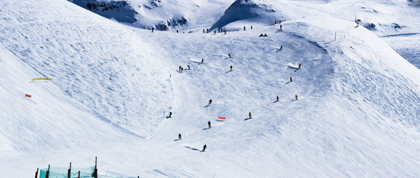 Panoramic view of people skiing on snowcapped mountain