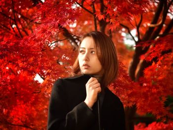 Portrait of beautiful young woman looking away during autumn