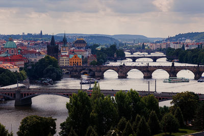 Arch bridge over river against cloudy sky